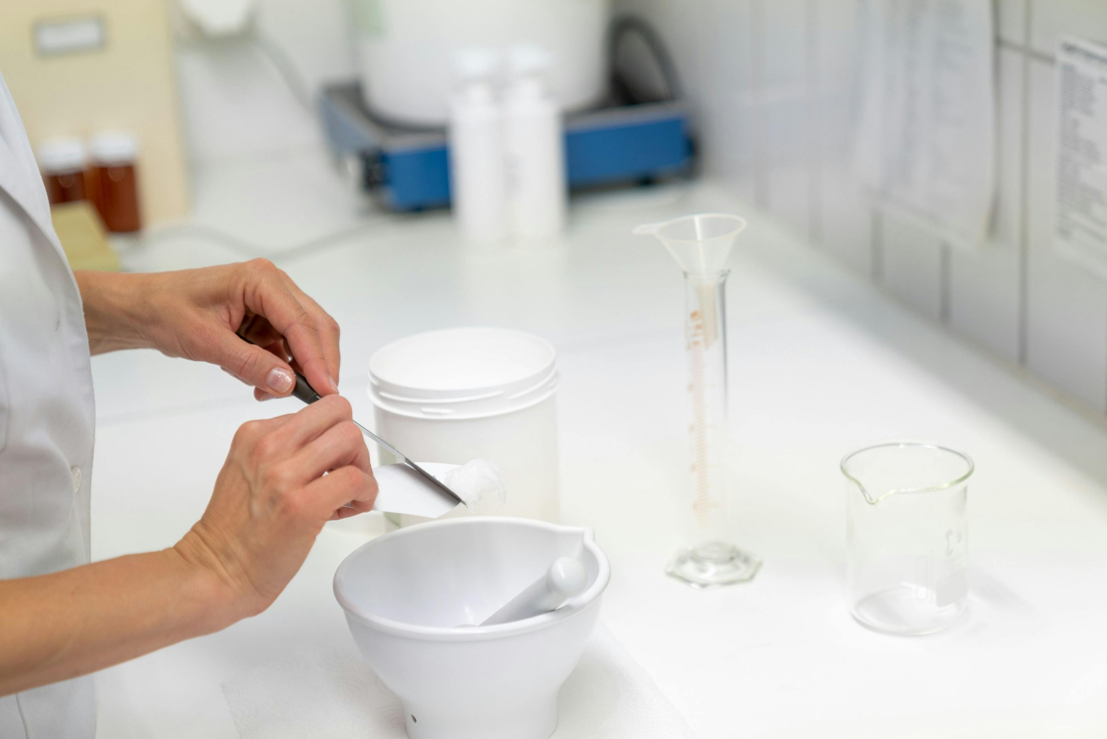 Pharmacist in the laboratory mixing an ointment in a bowl