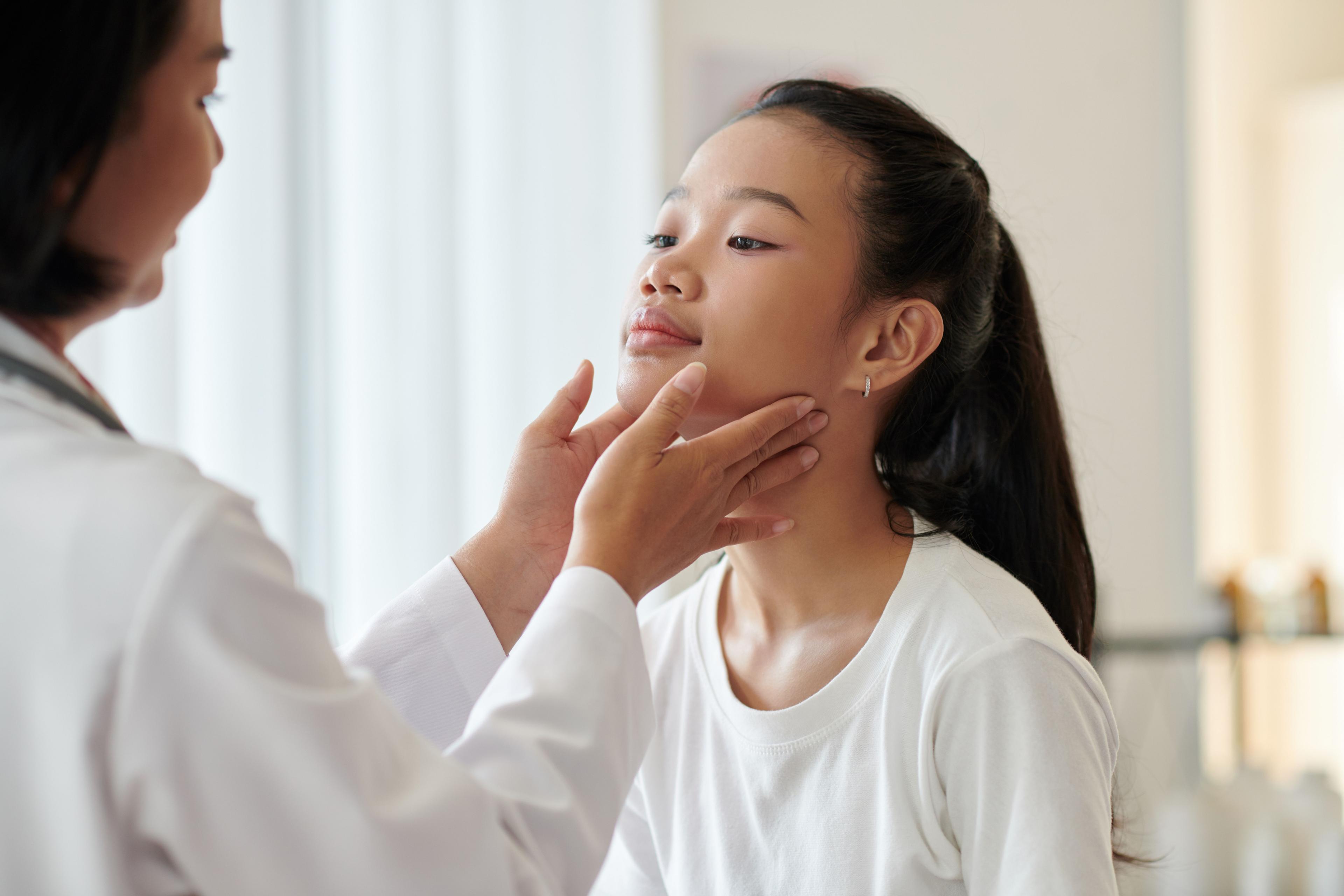 Dermatologist examining face of teenage girl