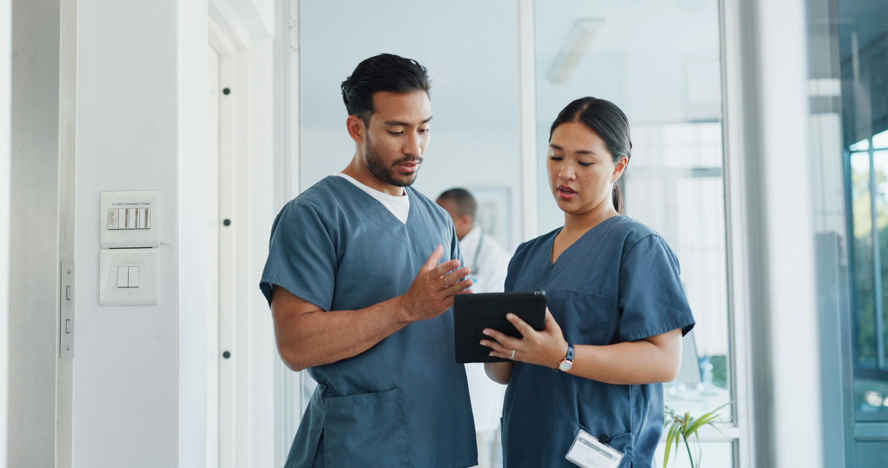 Two physician assistants gather around a tablet